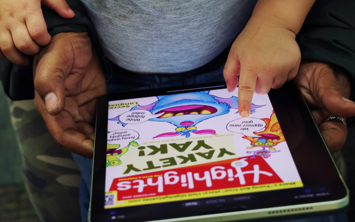 Child and adult reading Highlights magazine on Flipster